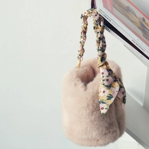 Détail du sac à main en fausse fourrure avec foulard en soie tressé dans la chaîne dorée