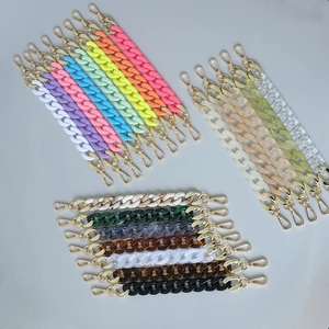 Macro shot of colorful acrylic fishbone bag chains with golden metal lobster clasps