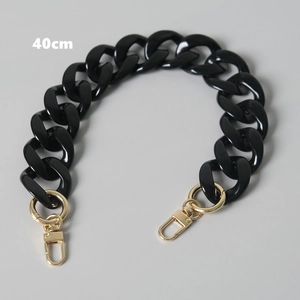 Detailed view of a 40cm black resin bag chain with polished gold swivel lobster clasps