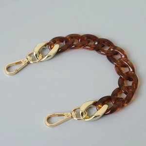Detail of tortoise shell acrylic chain link with golden metal lobster clasps for bags