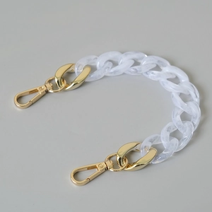 Close-up of white marble acrylic chain with gold metal lobster clasps for handbags