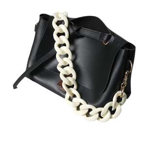 Chic black faux leather handbag featuring a chunky contrast cream resin chain strap