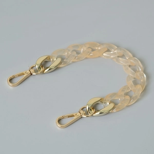 Close-up of translucent amber acrylic flat curb chain with gold-tone metal lobster clasps