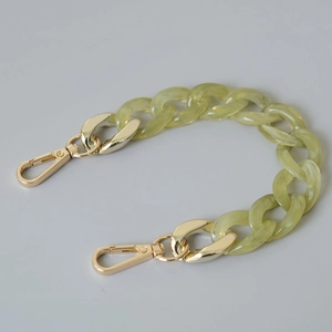 Close-up of light green acrylic fishbone chain with golden lobster clasps for bags