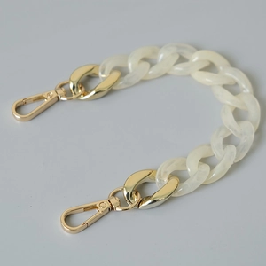 Detail view of chunky white marble acrylic links and golden metal lobster clasps