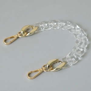 Detail of transparent acrylic fishbone chain with premium golden metal lobster clasps