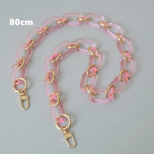 Dettaglio catena per borsa 80cm in acrilico rosa con anelli dorati e chiusure a molla