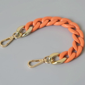 Detail of bright orange resin fishbone chain with shiny gold metal lobster clasps
