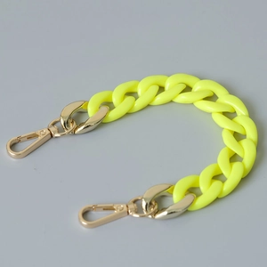 Detailed macro view of fluorescent yellow acrylic fishbone chain with gold lobster clasps