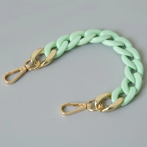 Close-up of mint green acrylic fishbone chain with gold lobster clasps for bags