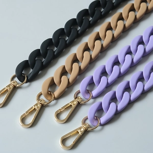 Close-up of matte acrylic resin bag chains with golden lobster clasps in various colors