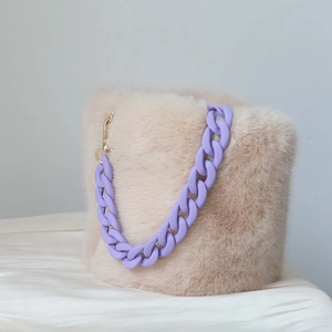 Detail of plush beige bucket bag with matte purple acrylic resin chain and gold metal hooks