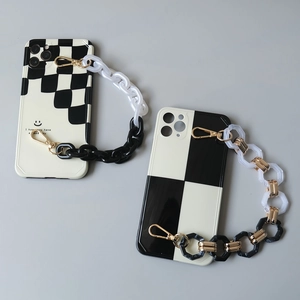 Détail de coques de téléphone à damier noir et blanc avec chaînes à main en résine épaisse