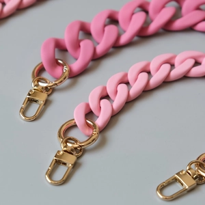 Close-up of matte pink chunky resin bag chain with golden metal spring buckles