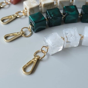 Detailed view of vintage acrylic resin square chain links with gold lobster clasps