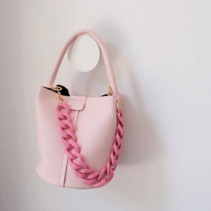 Detail of light pink bucket bag with litchi texture and matte resin chain