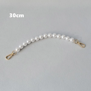 Detail view of 30cm white pearl purse chain strap with golden metal lobster clasps