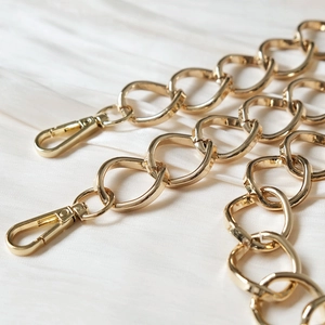Detailed view of glossy golden alloy metal replacement chain with lobster clasps for handbags