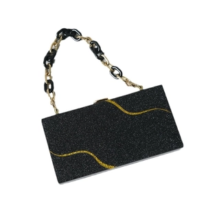 Elegante pochette da sera in acrilico glitterato nero con motivi dorati e tracolla a catena