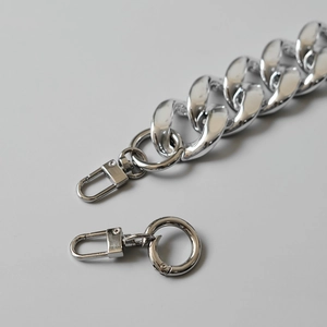 Close-up of polished silver chain strap with lobster clasp for handbags