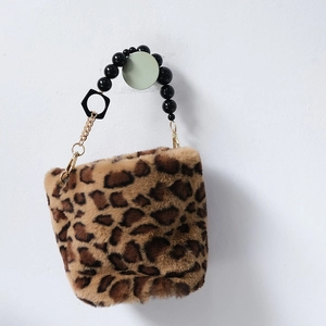 Detail of leopard print plush handbag with black beaded handle and gold hardware