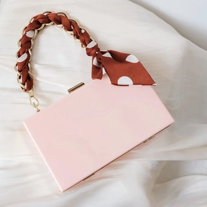 Detail der rosa Abendtasche mit Seidenschal gewebtem Goldketten Griff und Schleife