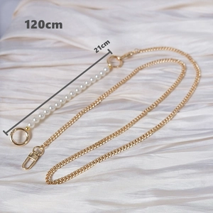 Close-up of 120cm gold metal chain strap with 21cm white pearl splice on silk background