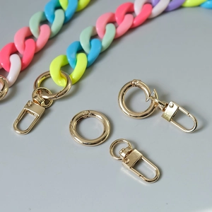 Close-up of colorful resin chain links with polished gold metal lobster clasps and rings