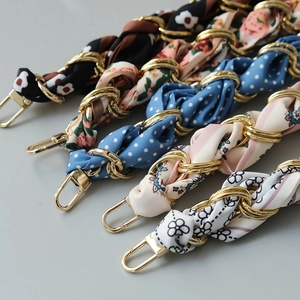 Detailed view of assorted silk-wrapped golden chain bag straps with decorative prints