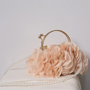Detail of elegant beige evening bag with ruffled fabric petals and pearl strap