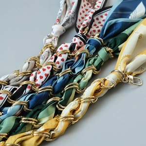 Detail of silk scarves wrapped around gold chains for handbags in various colorful patterns