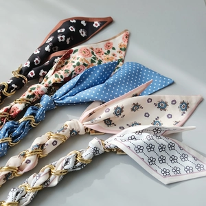 Close-up of assorted silk scarf wrapped gold chain straps for handbags and accessories