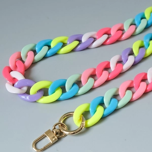 Detail of candy-colored acrylic chain with golden lobster clasp and macaron links