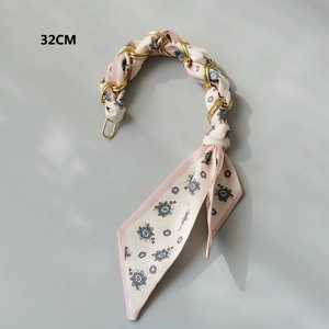 Close-up of a 32cm luxury gold chain entwined with a floral silk scarf bag strap accessory