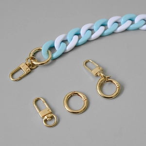 Close-up of blue and white acrylic fishbone chain with gold lobster clasps and rings