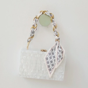 Elegant gold metal chain bag handle interwoven with floral silk scarf accessory