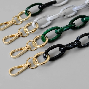 Close-up of vintage acrylic bag chains with marble patterns and gold metal lobster clasps