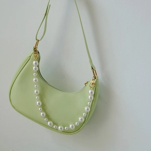 Détail du sac hobo vert clair avec chaîne en perles élégante et fermoirs dorés