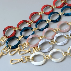 Detailed view of colorful acrylic resin chain straps with gold metal rings and lobster clasps