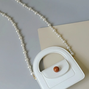 Détail du mini sac à main en cuir blanc avec finition mate et bandoulière en perles chic