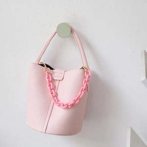 Detailansicht der rosa Beuteltasche aus genarbtem Leder mit dekorativer Harzkette