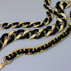 Nahaufnahme der schwarz-goldenen Harz-Taschenkette mit Karabinerverschluss und Gliedern