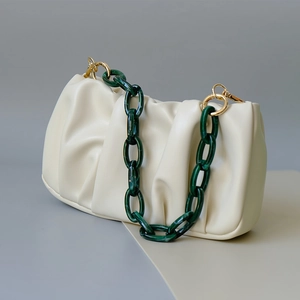 Close-up of cream cloud bag with dark green marble resin chain and golden metal rings