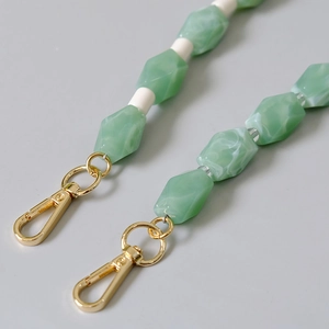Detail of green and white faceted resin beads with premium gold metal lobster clasps