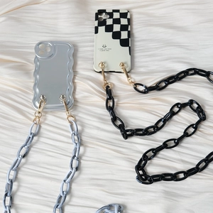 Close-up of chunky marble acrylic phone chains on wavy fabric background for crossbody