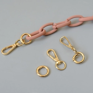 Close-up of matte peach acrylic chain with golden metal lobster clasps and spring rings