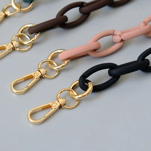 Detail of matte resin bag straps with gold lobster clasps in brown pink and black