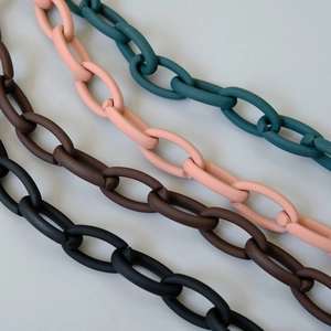 Detail of matte acrylic chain straps in green, pink, brown, and black for bags and phones