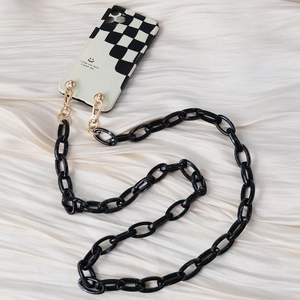 Close-up of black and white checkered phone case with chunky black acrylic chain strap