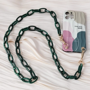 Detail of green marble resin chain with gold metal clasps on a stylish wavy phone case